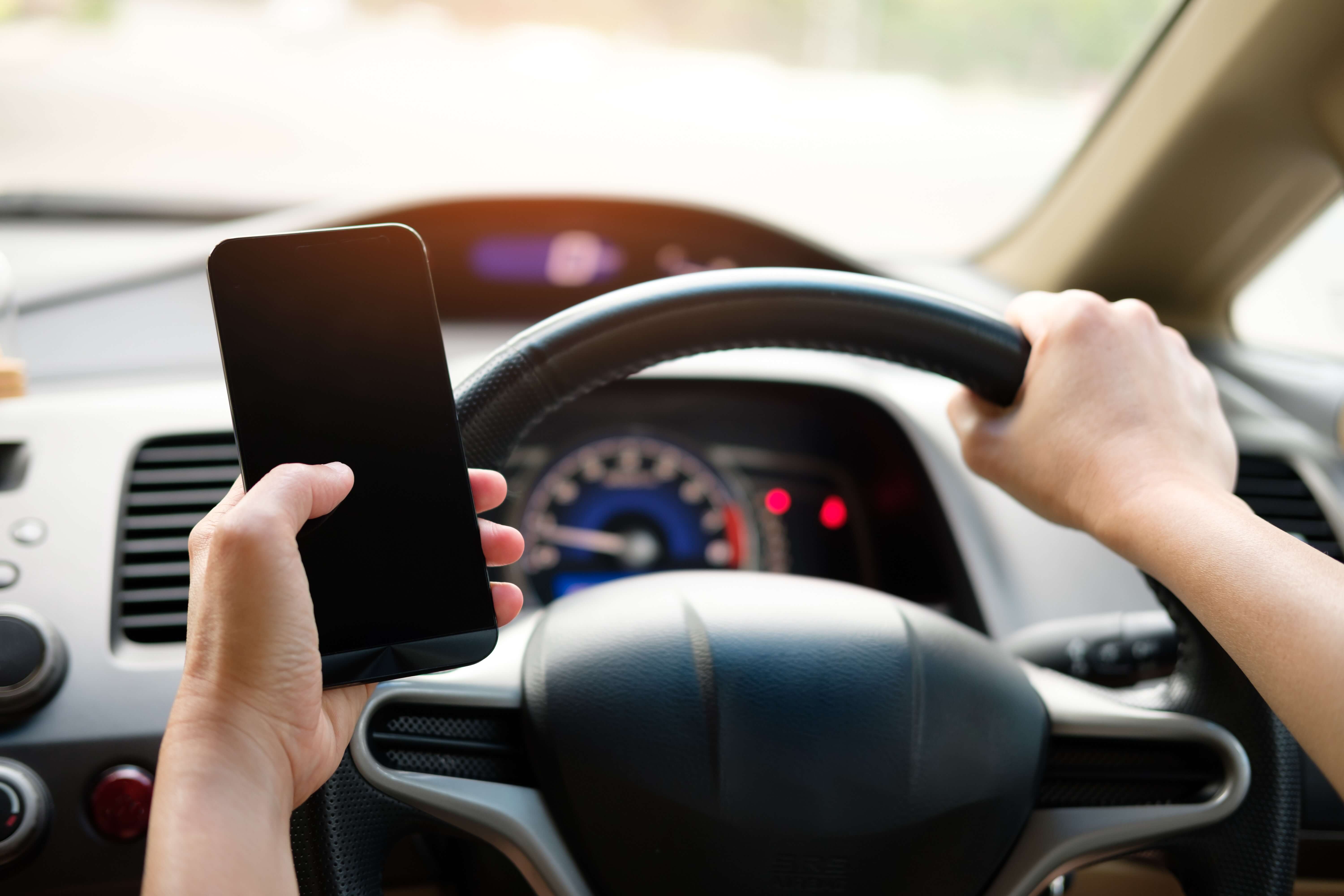 person-holding-black-smartphone-and-vehicle-steering-wheel-16.03.2020 (1)